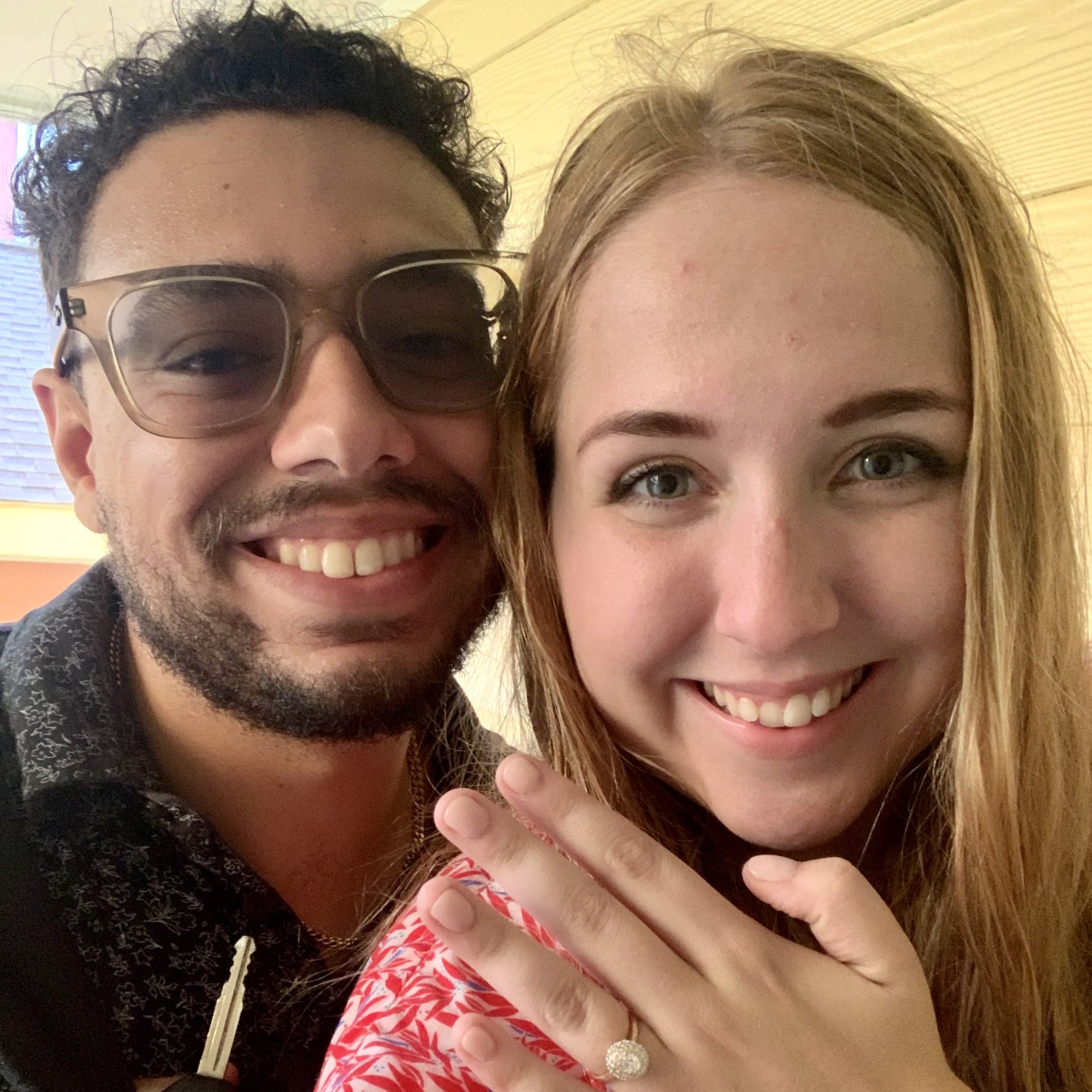 Jess and Nick are taking a selfie together with Jess's engagement ring on show. Both are smiling at the camera.